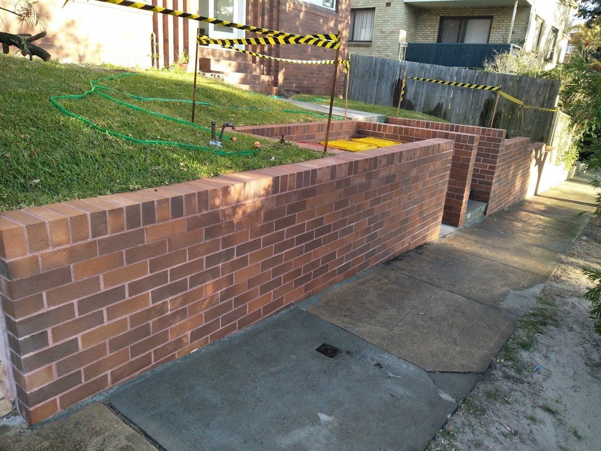Retaining wall with bin enclosure and brick fence in Maroubra, Sydney